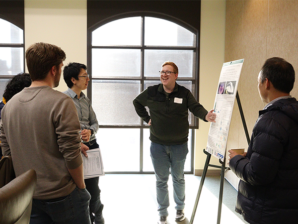 A participant of the AI retreat shares their research to a group of onlookers