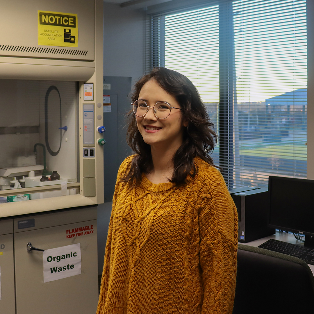 Photo of Brynnen Hendrix poses in a research lab in the University Boulevard Office Building (UBOB)