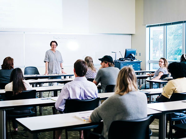 Ellyn Grady stands at the front of a classroom, teaching.