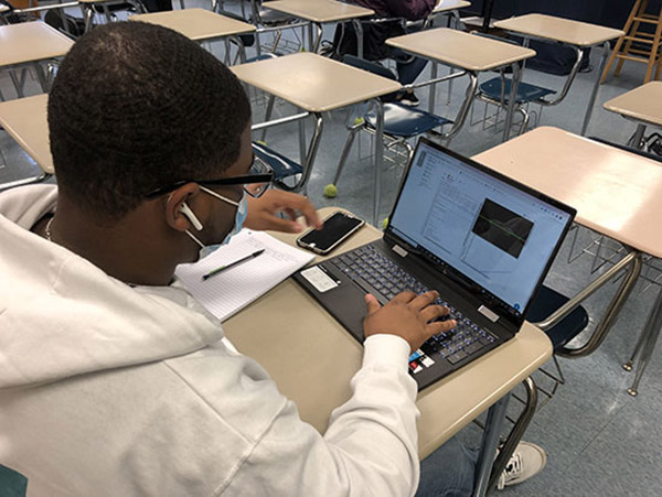 student working on physics assignment on laptop