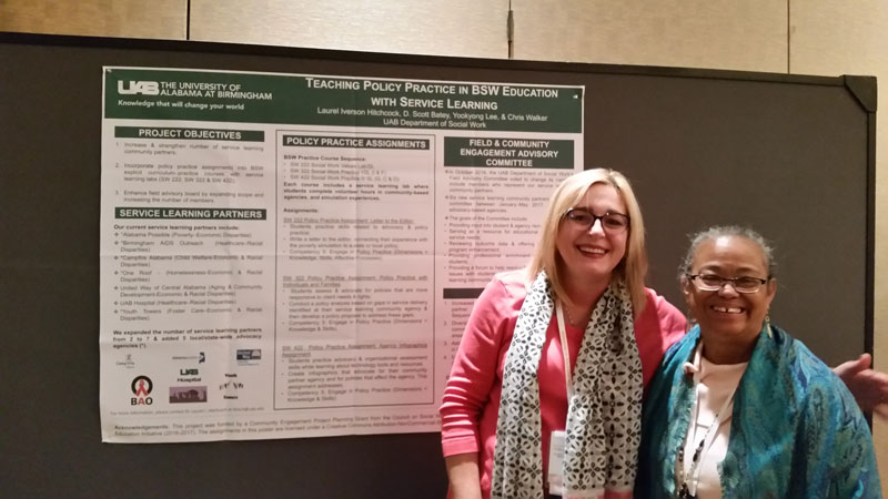 Laurel Hitchcock with other UAB faculty member in front of poster presentation.