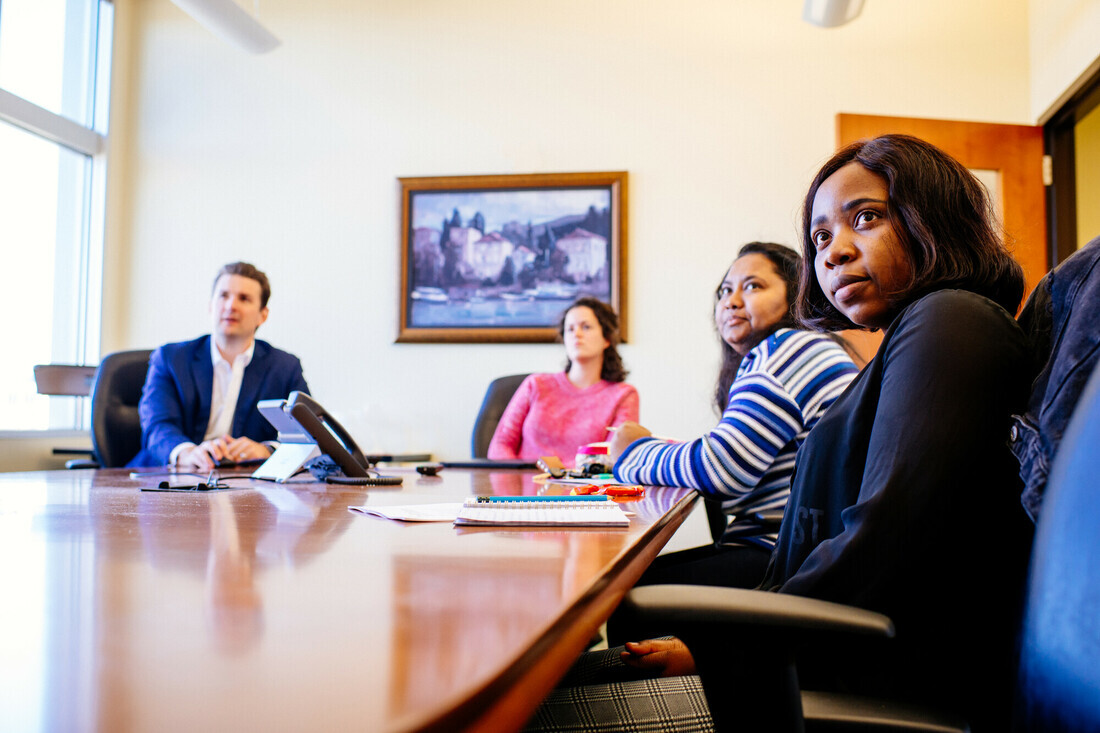 Photo of Dr. Chris Biga discussing material with students in a conference room.
