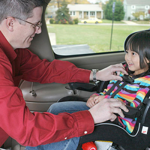 Child being buckled into a carseat