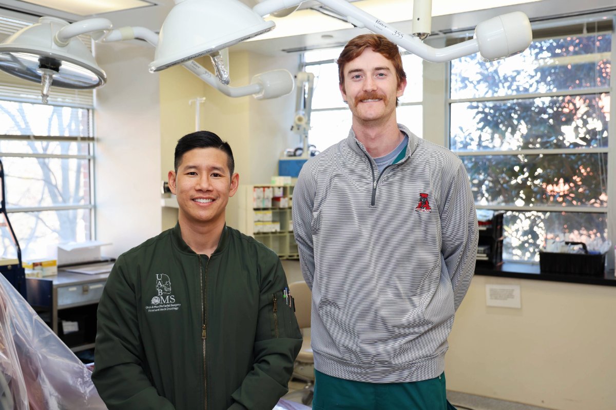 Dr. Le and Jack Shepherd smiling for a photo in the OMFS clinic at the UAB School of Dentistry