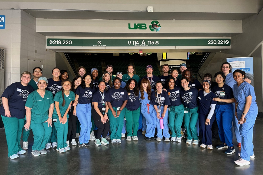 Group photo of student residents and faculty at TeamSmile event at Bartow arena