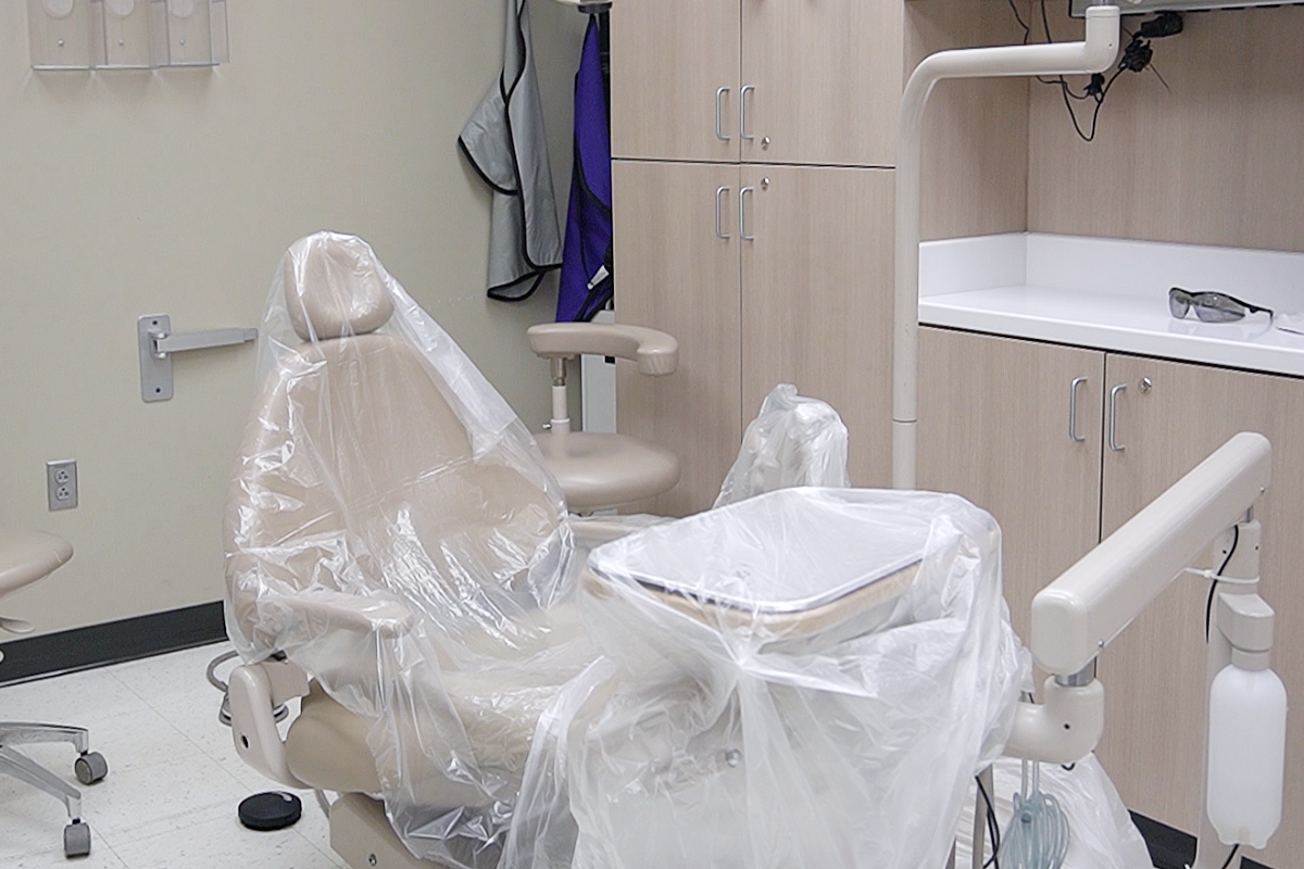 A photo one of the dental chairs in the UAB Civitan Sparks Dental Clinic. Clinic chair, cabinets, and xray equipment are seen in the background.