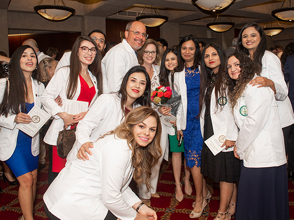 IDP students celebrate their White Coat Ceremony with Drs. Stephen and Sonya Mitchell (center)