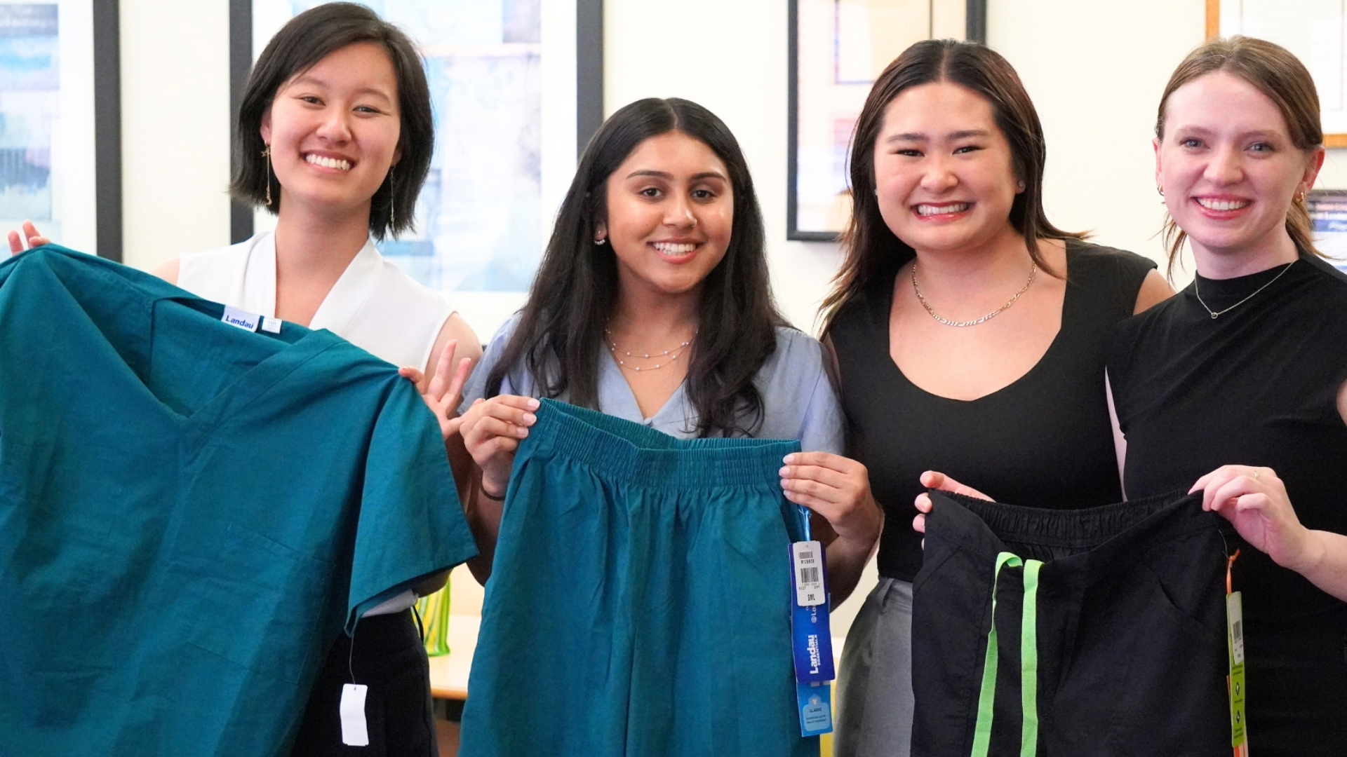 Four new Dental Students Smiling with Scrubs