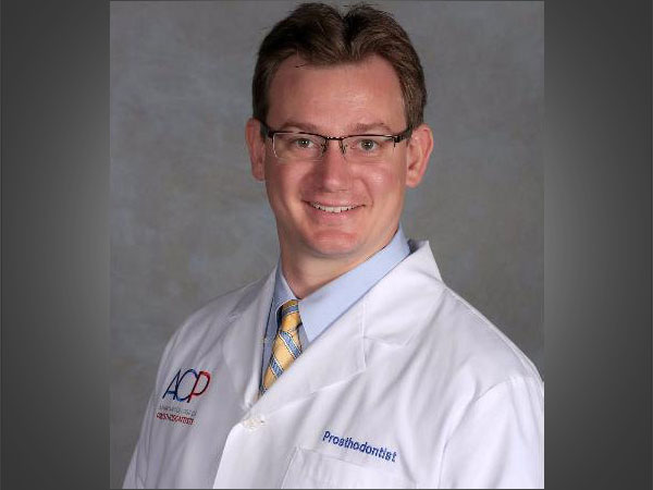 Dr. Michael Kase in his white coat and glasses. 