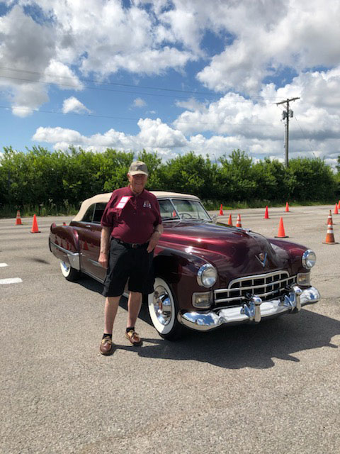 Dr. Petznick standing in front of vintage car.