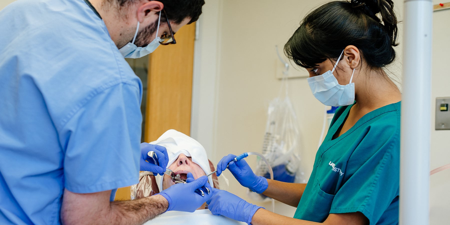 Two dentists examining the mouth of a patient.