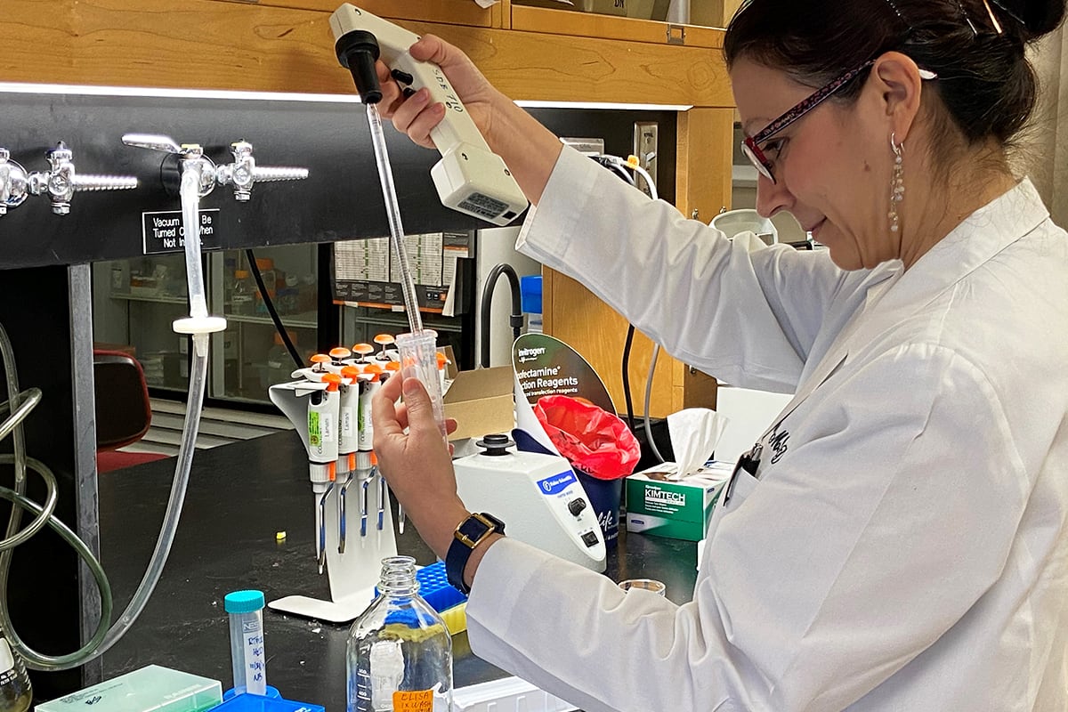 Researcher using a pipette in the lab.