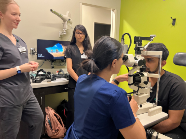 Optometry students conducting eye exam