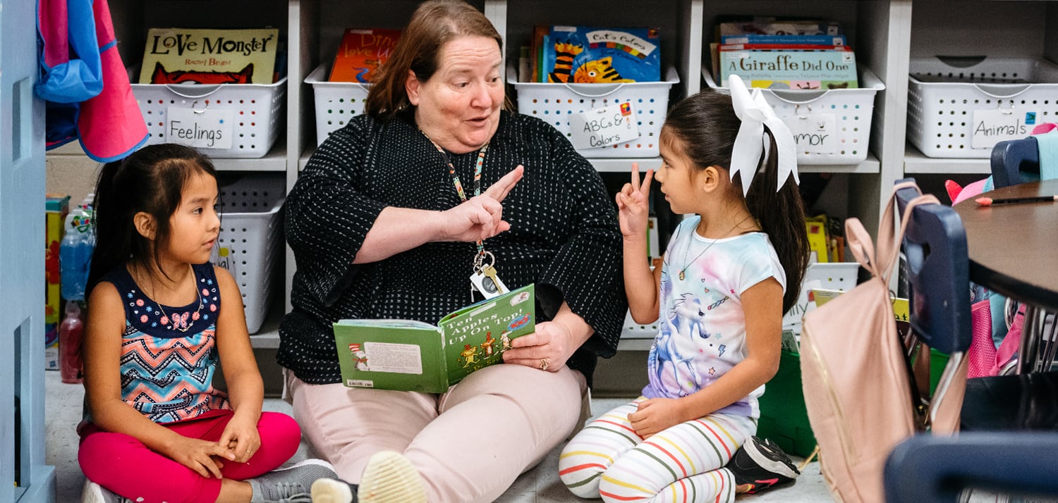 woman reading a book to kids