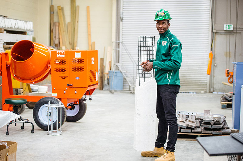 A student in a UAB hard hat working in the civil engineering lab. 
