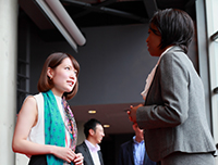 An Asian woman speaks with an African American woman at a conference