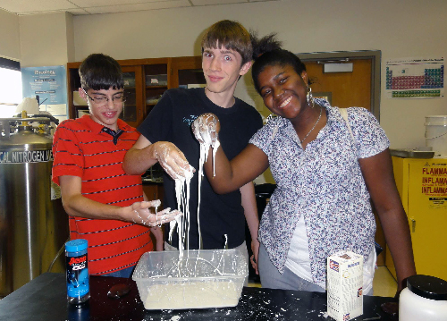 Students with hands covered in white goopy material. 
