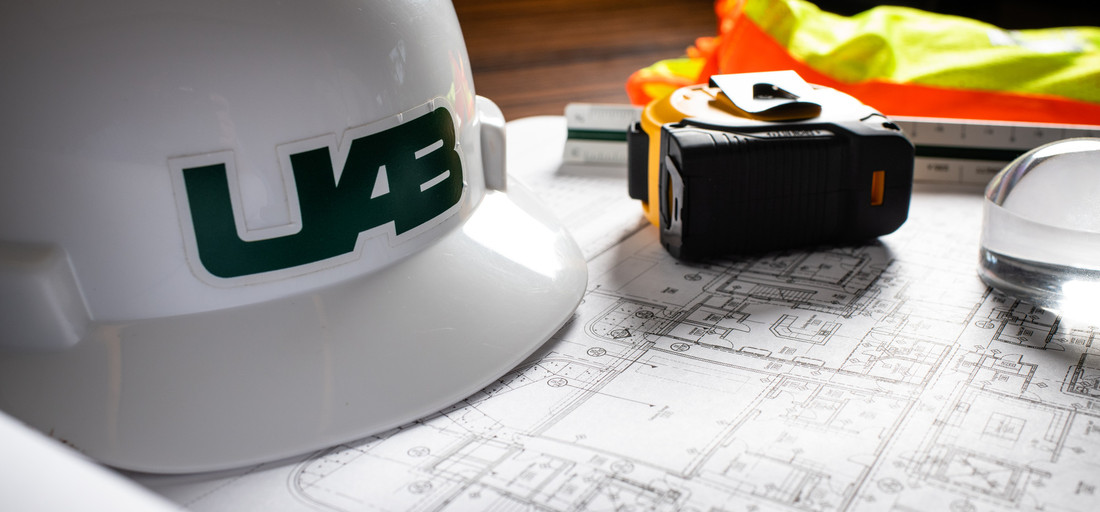 UAB hardhat, tape measure, and building plans