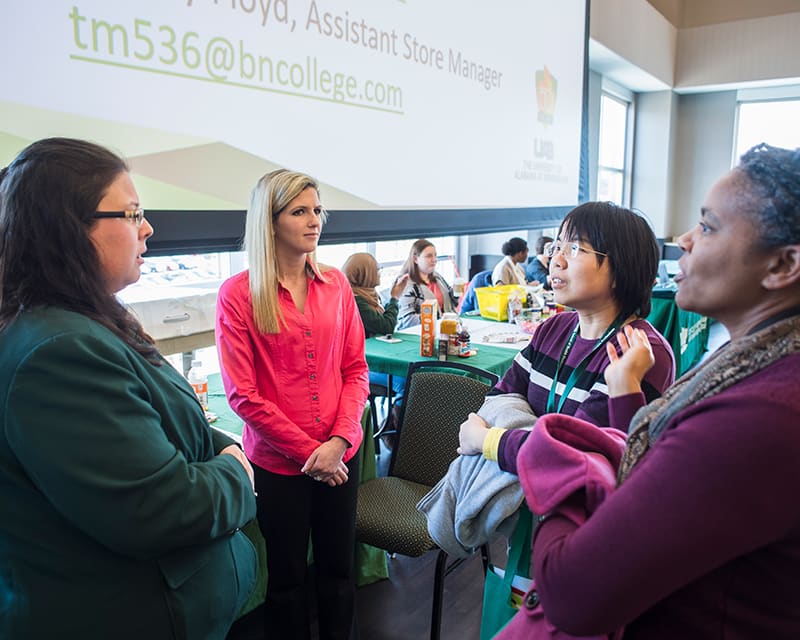 Group of UAB staff talking at an event