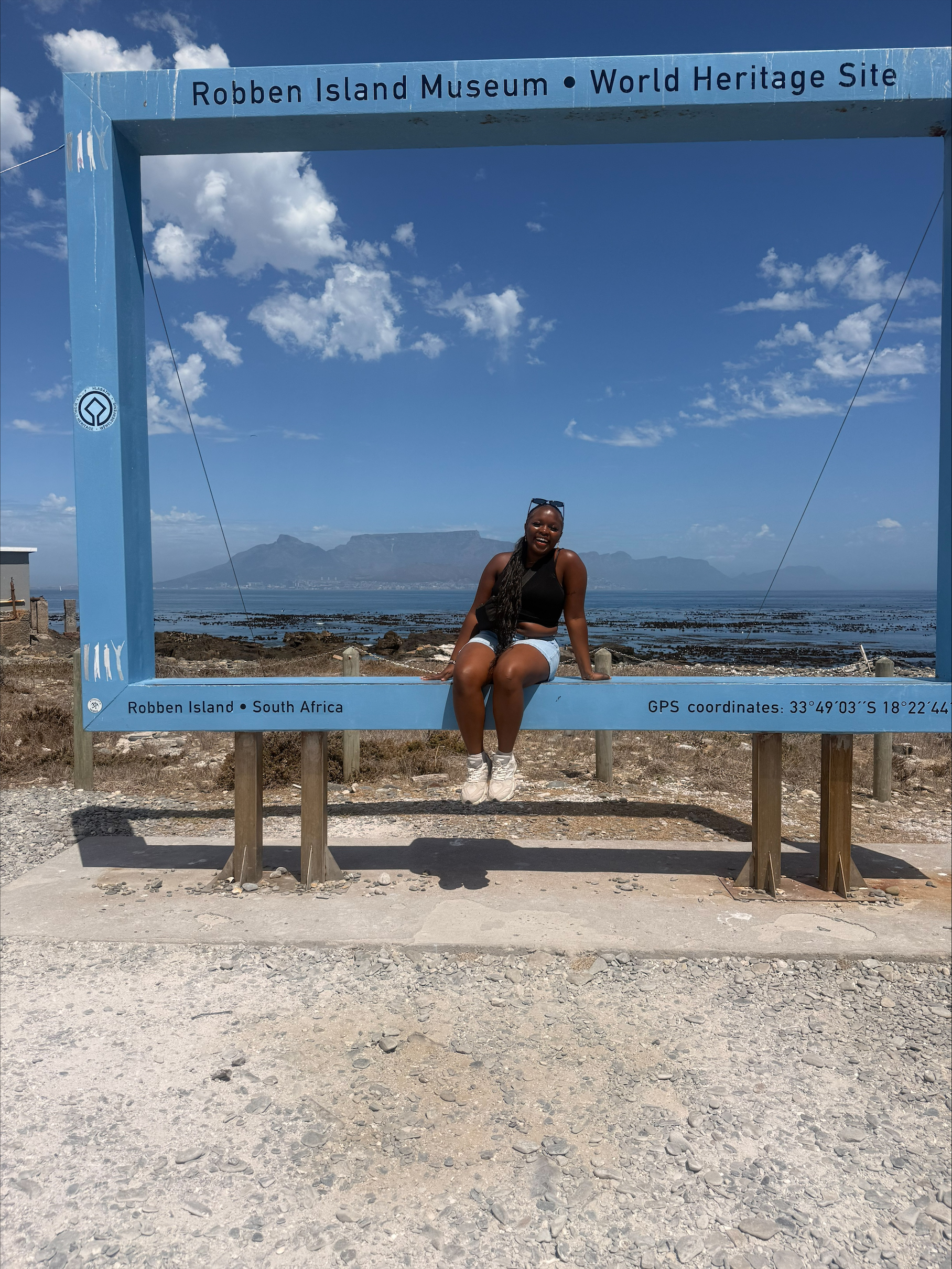 Keziah sitting on a sign.