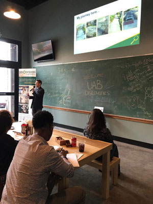 Daniel Kuhman presenting to a crowd of people.