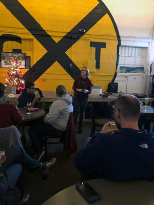 Jessica Kepple lecturing at Ghost Train in front of crowd.