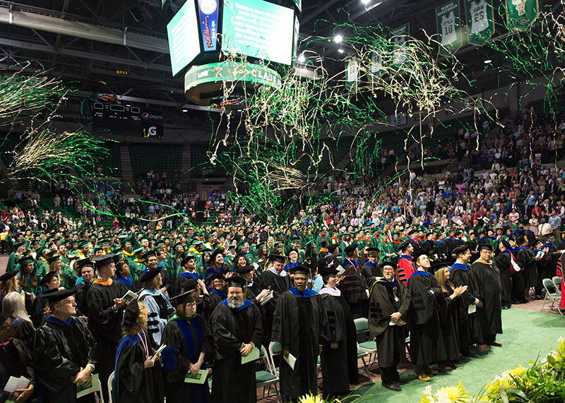 Students in caps and gowns celebrating.