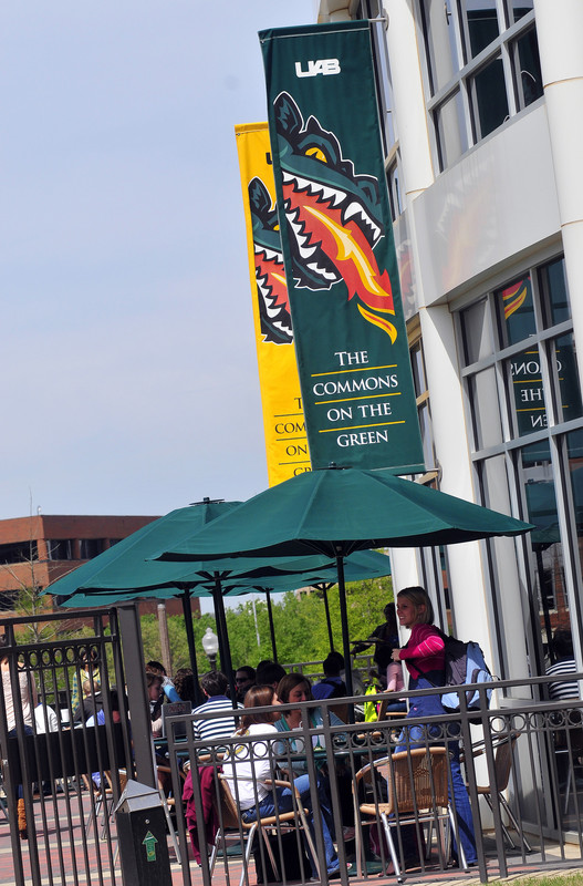 Students and employees pictured sitting at the outdoor dining area at UAB's Commons on the Green