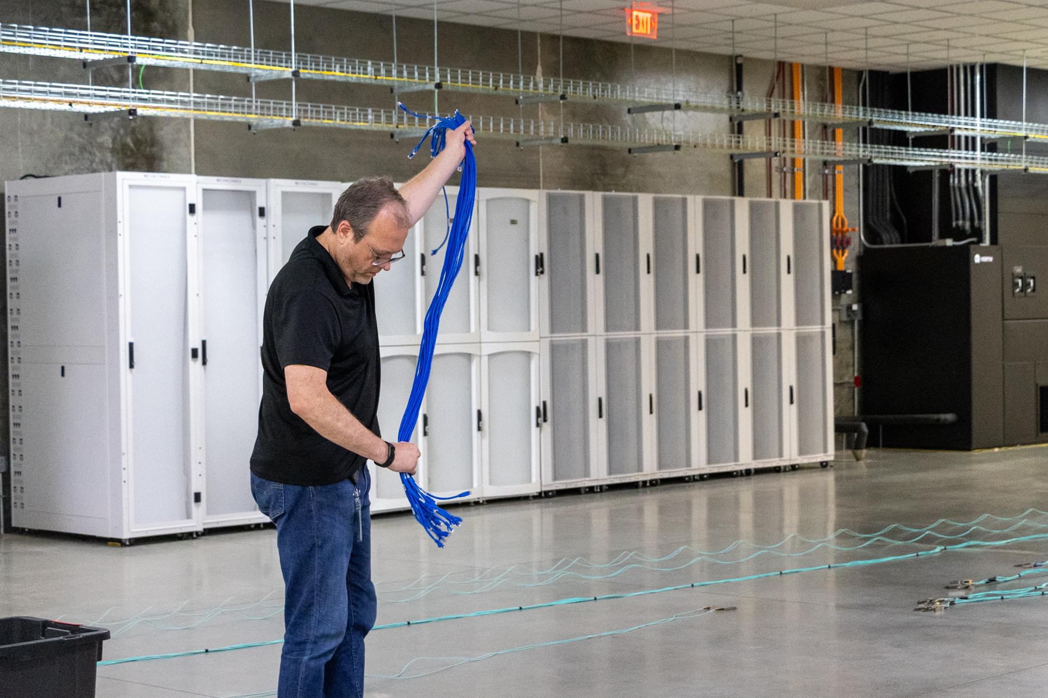 Data center technician working with network cables