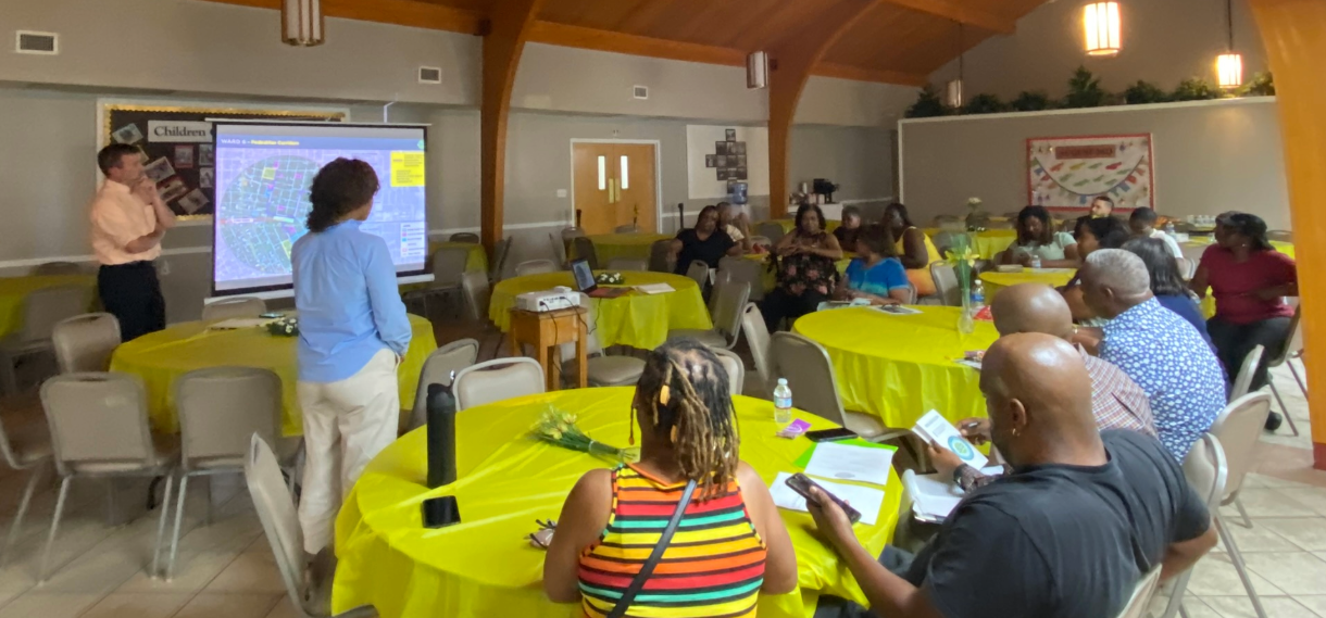 People sit at round tables  at a community event.