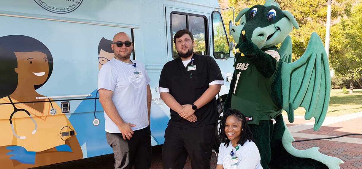 Blaze and three others pose outside the Mobile Wellness van.