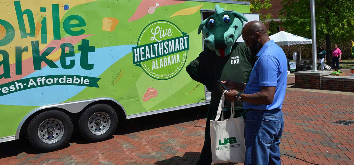 Blaze inspects the bag held by a man outside the Mobile Market van.