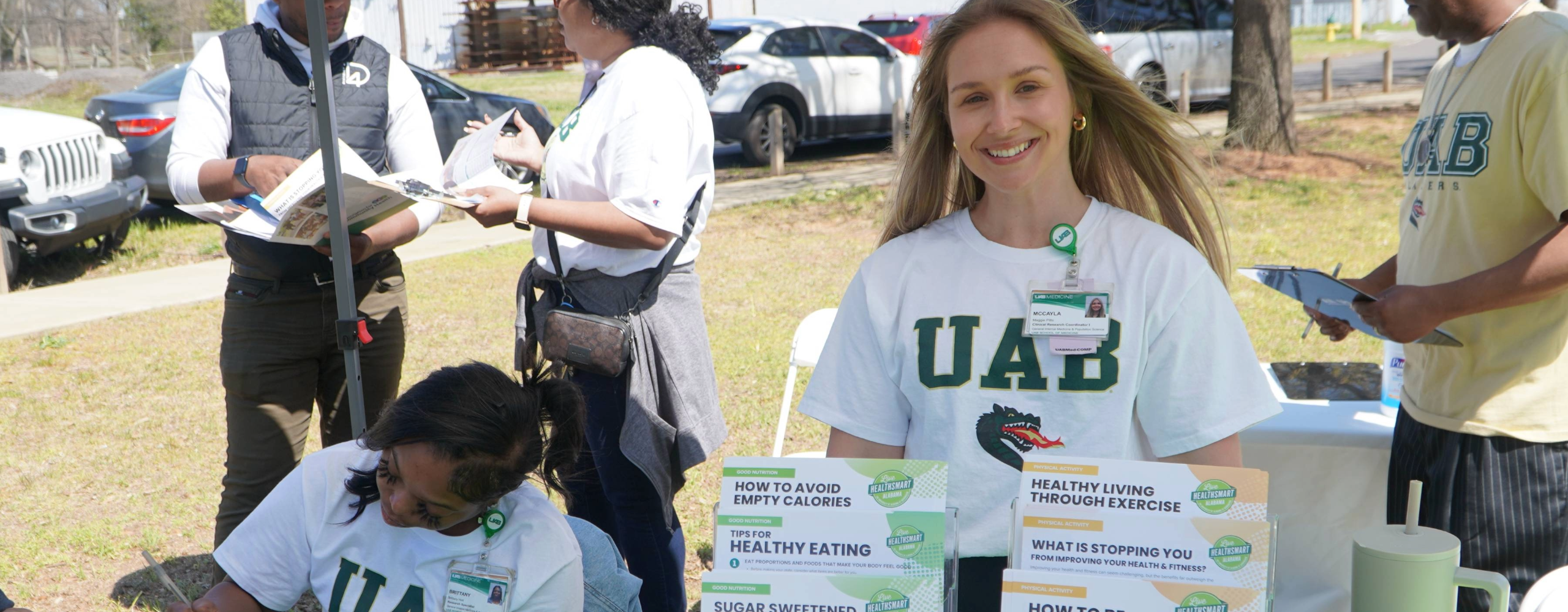 Volunteers standing at a fair info table. 