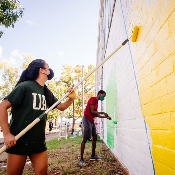 student working on a mural
