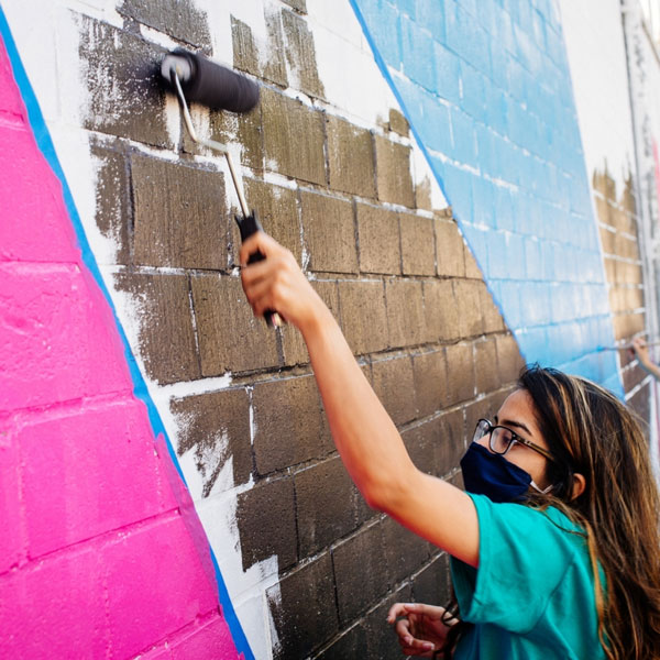 student working on a mural