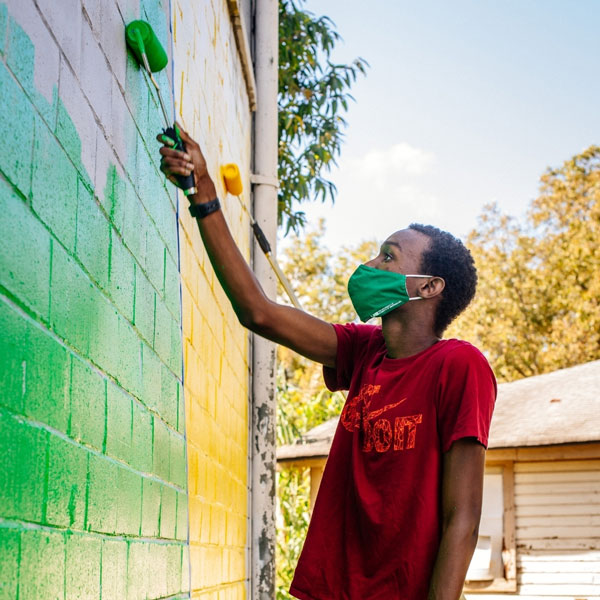 student working on a mural