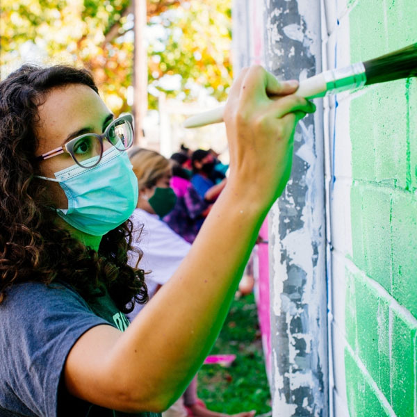 student working on a mural