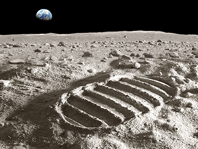 Footprint of astronaut on the moon with earth above the horizon. Photo of the earth has been used with courtesy of NASA database. Photo of the moon surface and the footprint has been created in the studio.