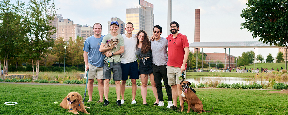 Group of six fellows at Railroad Park with their dogs and frisbees