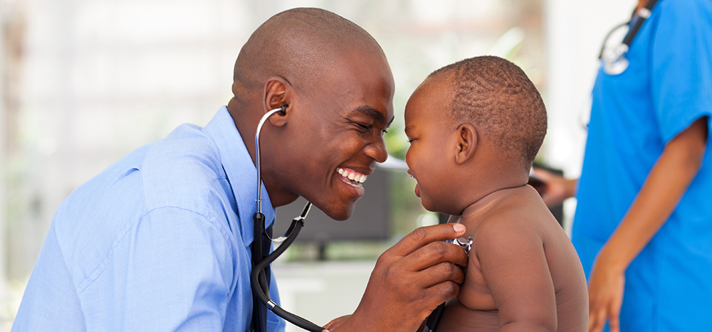happy african male doctor examining baby boy with female nurse on background