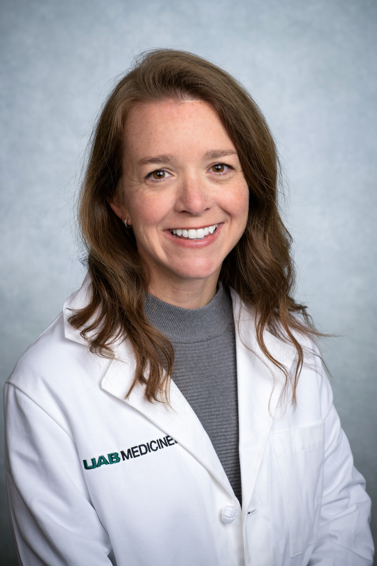 Headshot of Dr. Erin DeLaney, MD (Associate Professor, Family and Community Medicine) in white medical coat.