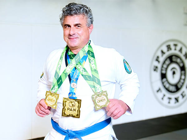 Distinguished professor Aurelio Galli, Ph.D., D.S.c, poses with three award medals from the Pan American juice-jitsu competition.