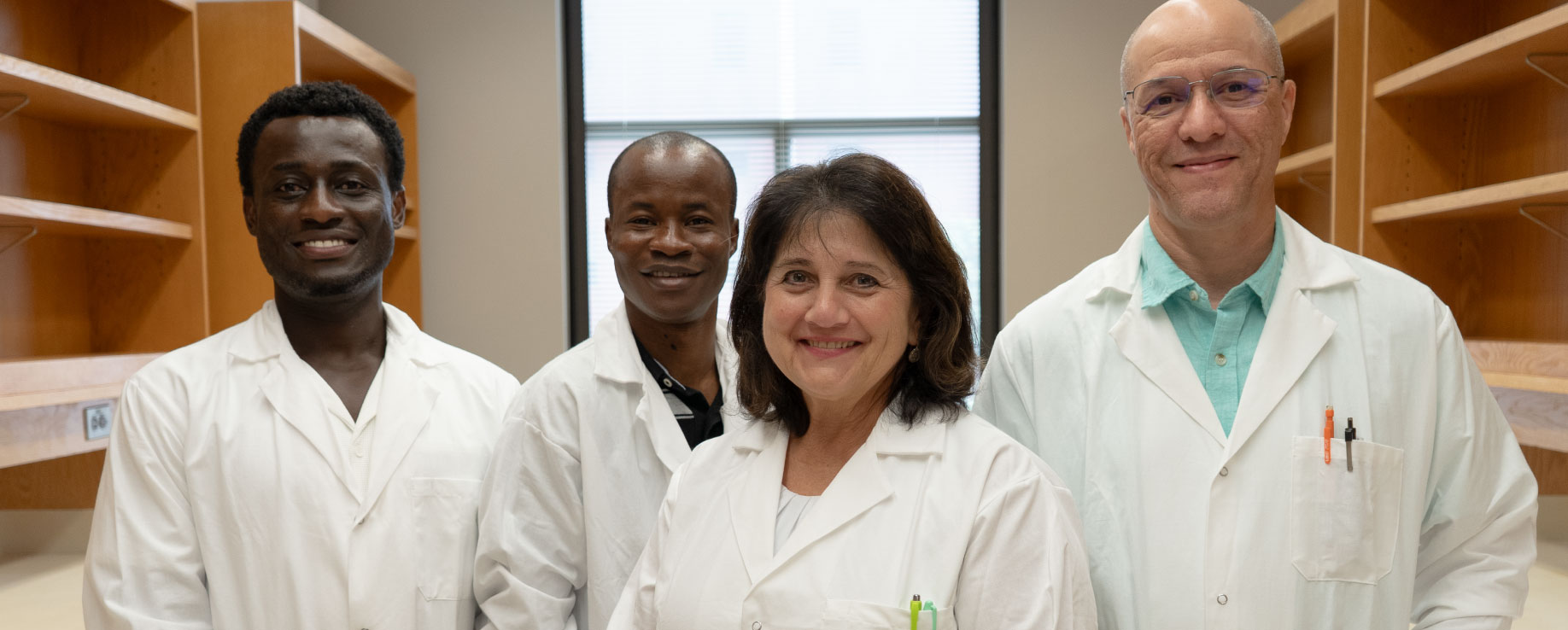 Corinne Augelli-Szafran standing with her laboratory team.