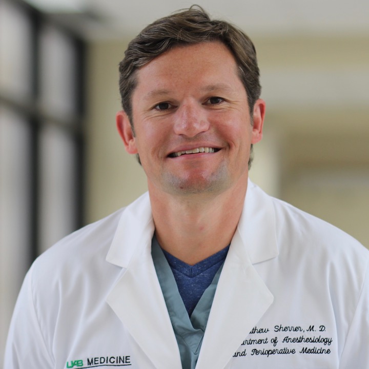 Man wearing UAB Medicine lab coat with embroidered name and Department of Anesthesiology and Perioperative Medicine text