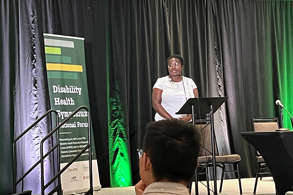 Assistant Professor Fedora Biney presents her research project on stage at the Disability Health Symposium.