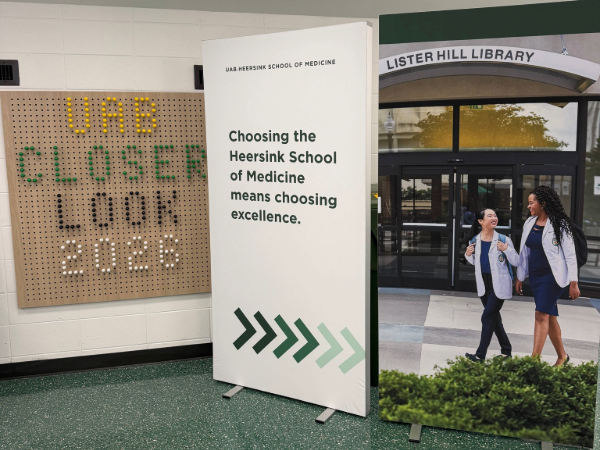 A decorative sign for UAB Closer Look next to a banner promoting Heersink School of Medicine.