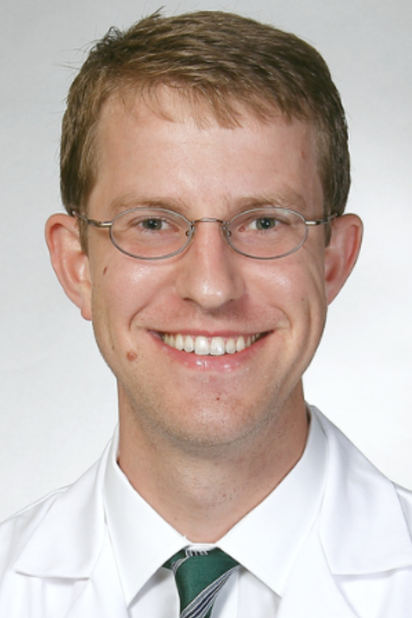 John Killian, M.D., stands in front a white background.