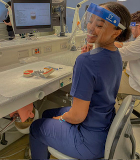 Jada Williams smiling, sitting at dental lab table