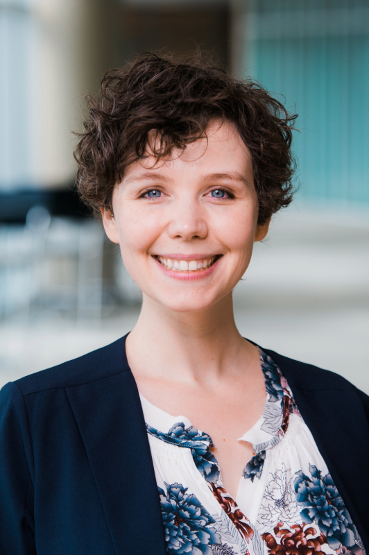 A headshot of Julienne Carstens, Ph.D., standing in front of a building.