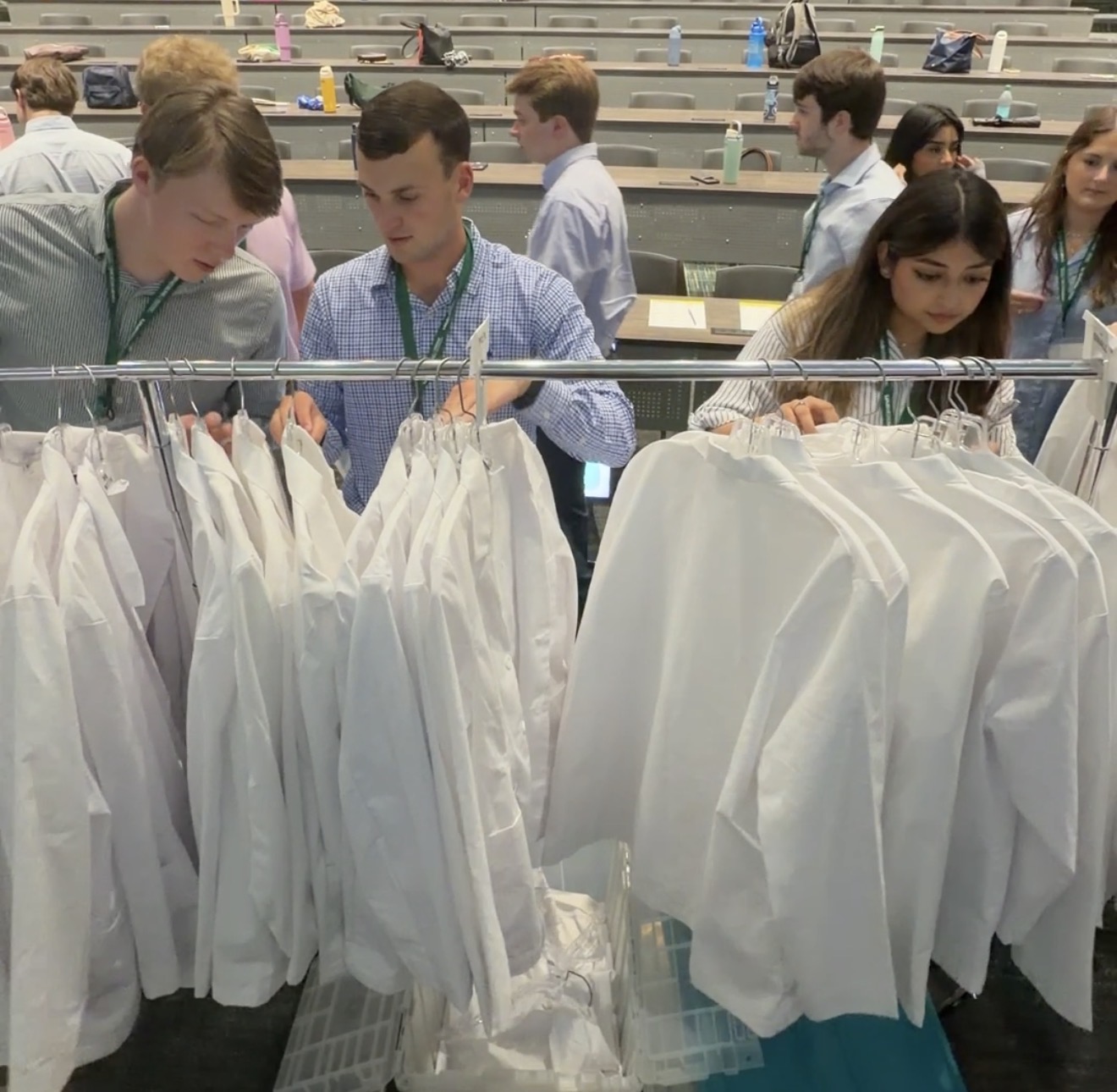 Medical students browse through new physician white coats.